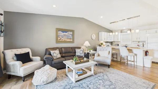 a kitchen with stainless steel appliances a refrigerator a stove a sink a dining table and chairs