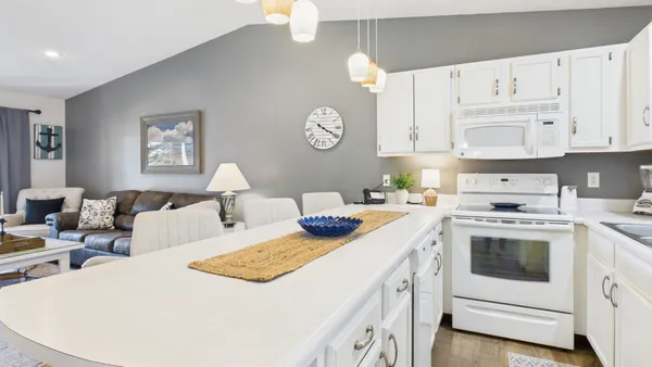 a kitchen with stainless steel appliances a white refrigerator a sink a stove and white cabinets