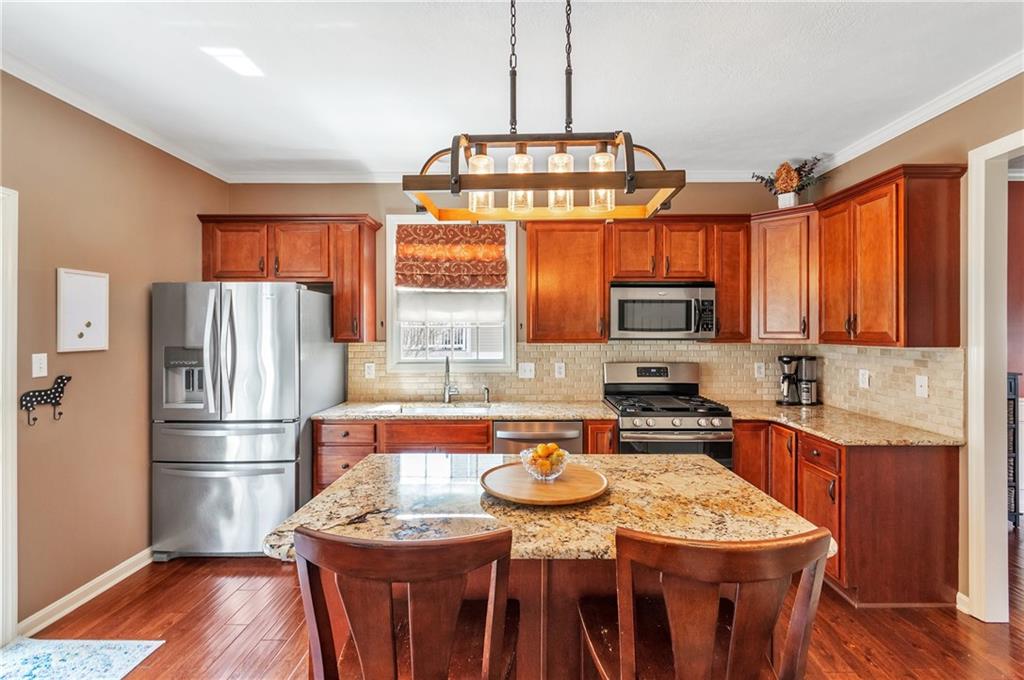 5012 Silver Oaks Drive McKees Rocks, PA 15136 - Photo 9 of 25 a kitchen with stainless steel appliances granite countertop a refrigerator a stove top oven a sink dishwasher and white cabinets with wooden floor