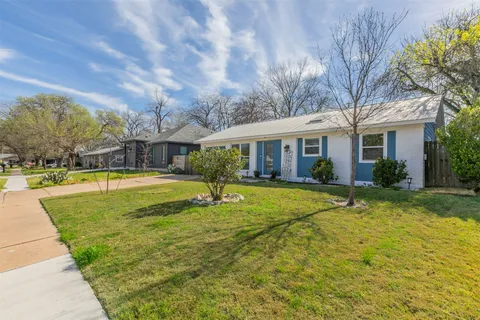 a view of house with swimming pool and a yard