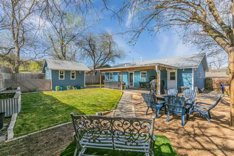 a view of a backyard with table and chairs and wooden fence