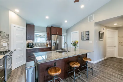 a kitchen with stainless steel appliances granite countertop a stove refrigerator and cabinets