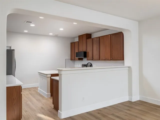 a view of a kitchen with wooden floor and a fireplace