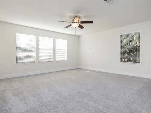 an empty room with closet and windows