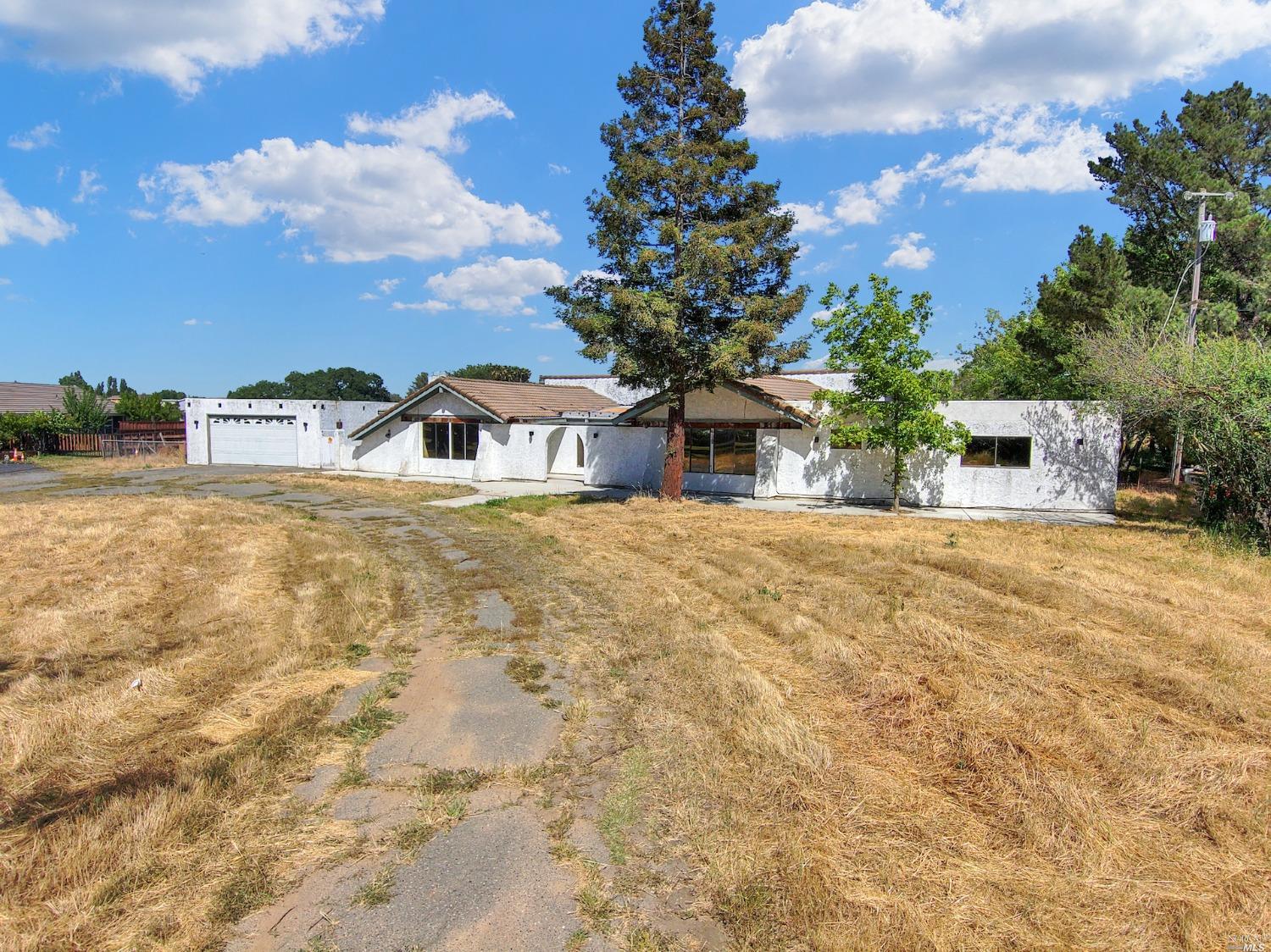 a view of a house with a yard and sitting area