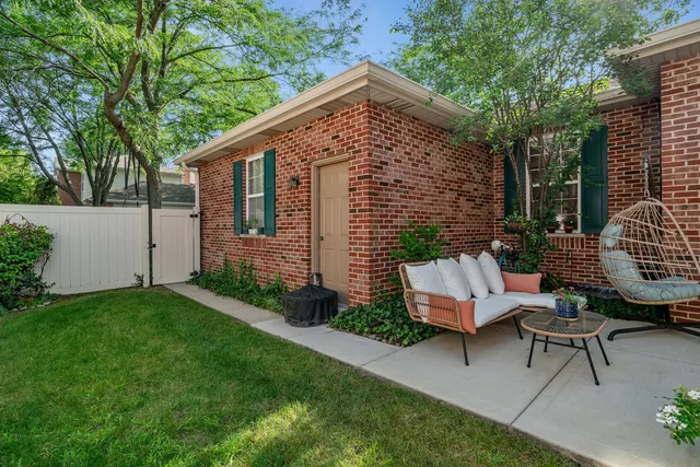 a view of a chair and table in backyard of the house