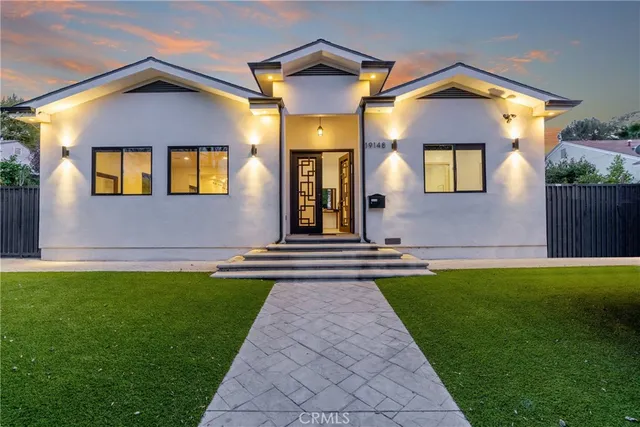 a front view of a house with a yard and a garden
