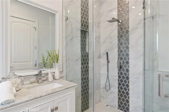 a bathroom with a granite countertop sink a mirror a vanity and a shower