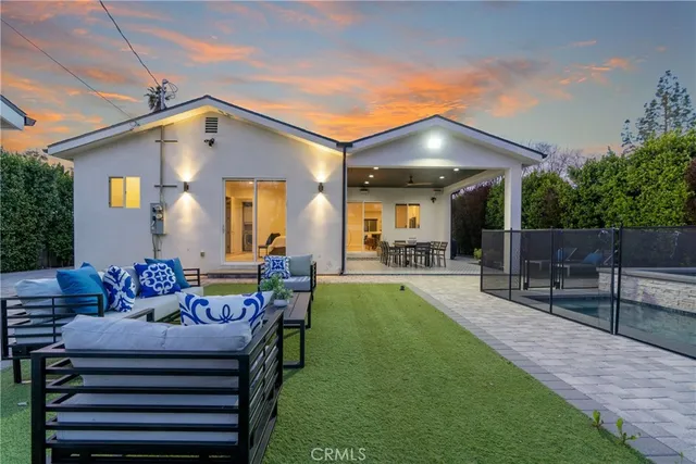 a view of a house with backyard and sitting area