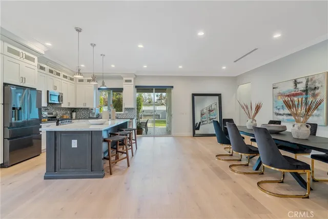 a view of kitchen with sink refrigerator dining table and chairs