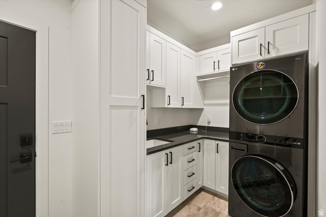 4499 North Seven Bridges Road, Unit 9 Eden, UT 84310 - Photo 15 of 65 Laundry area with white shaker-style cabinetry, dark countertops, an undermount sink, and a stacked washer and dryer