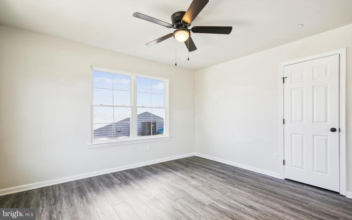 100 Metcalf Road Chestertown, MD 21620 - Photo 5 of 16 an empty room with wooden floor ceiling fan and windows