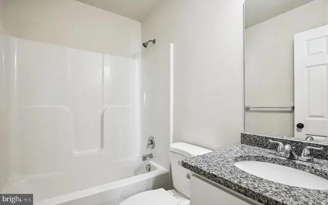 a kitchen with stainless steel appliances granite countertop a refrigerator and white cabinets