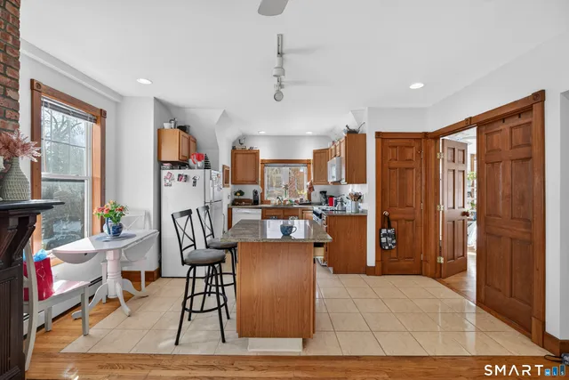 a kitchen with stainless steel appliances granite countertop a refrigerator and a dining table