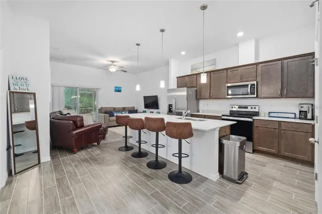 a large kitchen with lots of counter space a sink appliances and cabinets