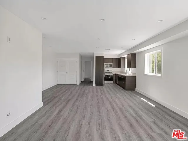 a big room with wooden floor windows and fireplace