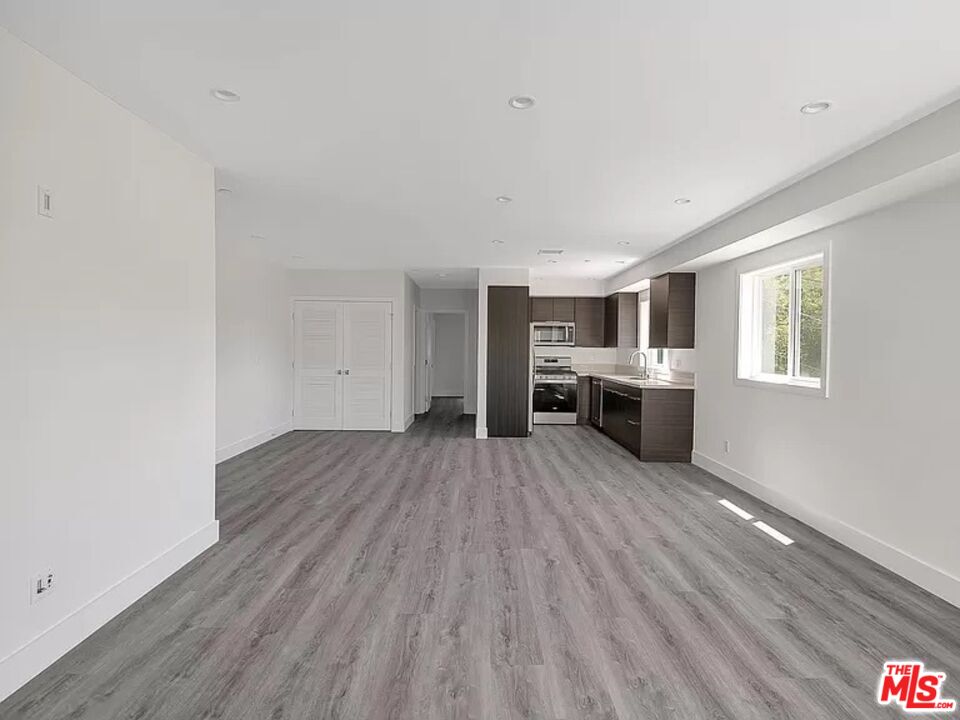 5750 Kester Avenue Van Nuys, CA 91411 - Photo 2 of 21 a big room with wooden floor windows and fireplace