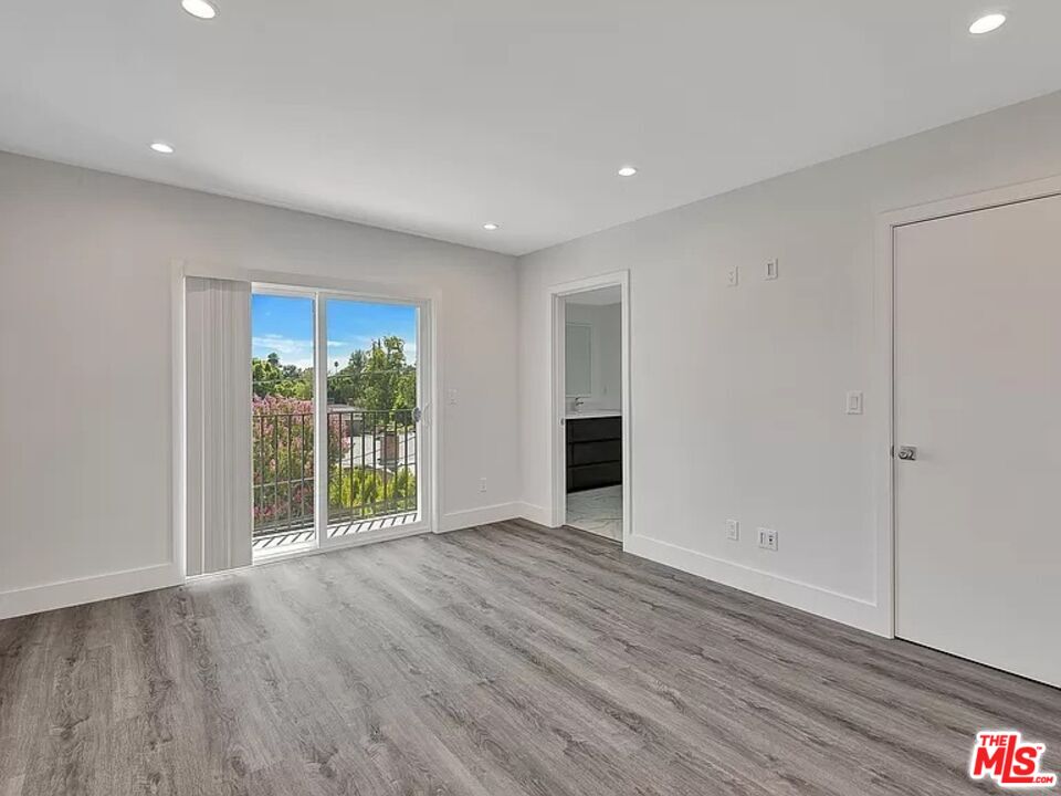 5750 Kester Avenue Van Nuys, CA 91411 - Photo 5 of 21 a view of an empty room with wooden floor and a window