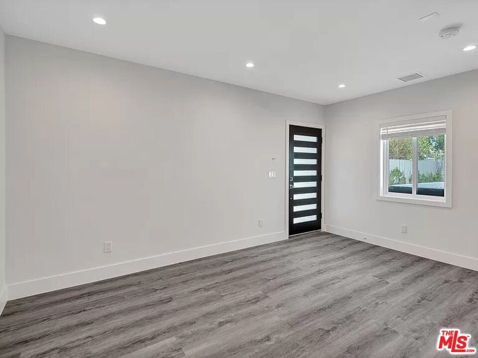 5750 Kester Avenue Van Nuys, CA 91411 - Photo 9 of 21 a view of an empty room with wooden floor and a window