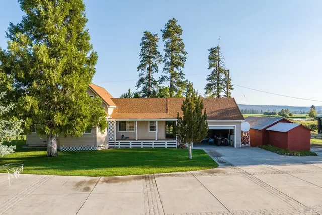 a front view of a house with a yard and trees