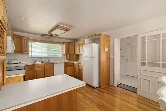 a kitchen with granite countertop a refrigerator and a stove top oven