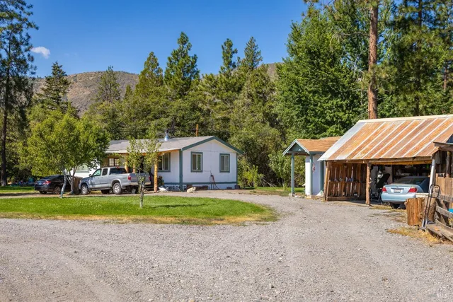 a view of a house with a yard and sitting area