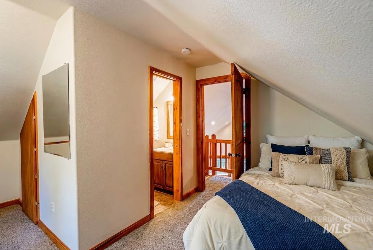 1409 Paul Bunyan Road McCall, ID 83638 - Photo 12 of 16 Bedroom featuring light colored carpet and connected bathroom