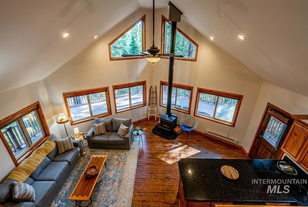 1409 Paul Bunyan Road McCall, ID 83638 - Photo 3 of 16 Living room featuring dark wood-style floors, recessed lighting, a wood stove, baseboard heating, and ceiling fan