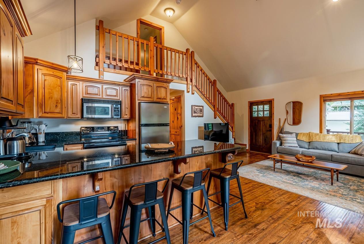 1409 Paul Bunyan Road McCall, ID 83638 - Photo 16 of 16 Kitchen with a breakfast bar, dark stone countertops, a peninsula, stainless steel appliances, and open floor plan