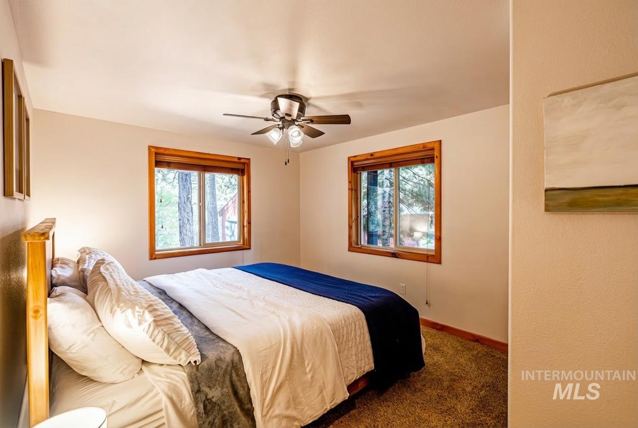 1409 Paul Bunyan Road McCall, ID 83638 - Photo 8 of 16 Carpeted bedroom with a ceiling fan and multiple windows
