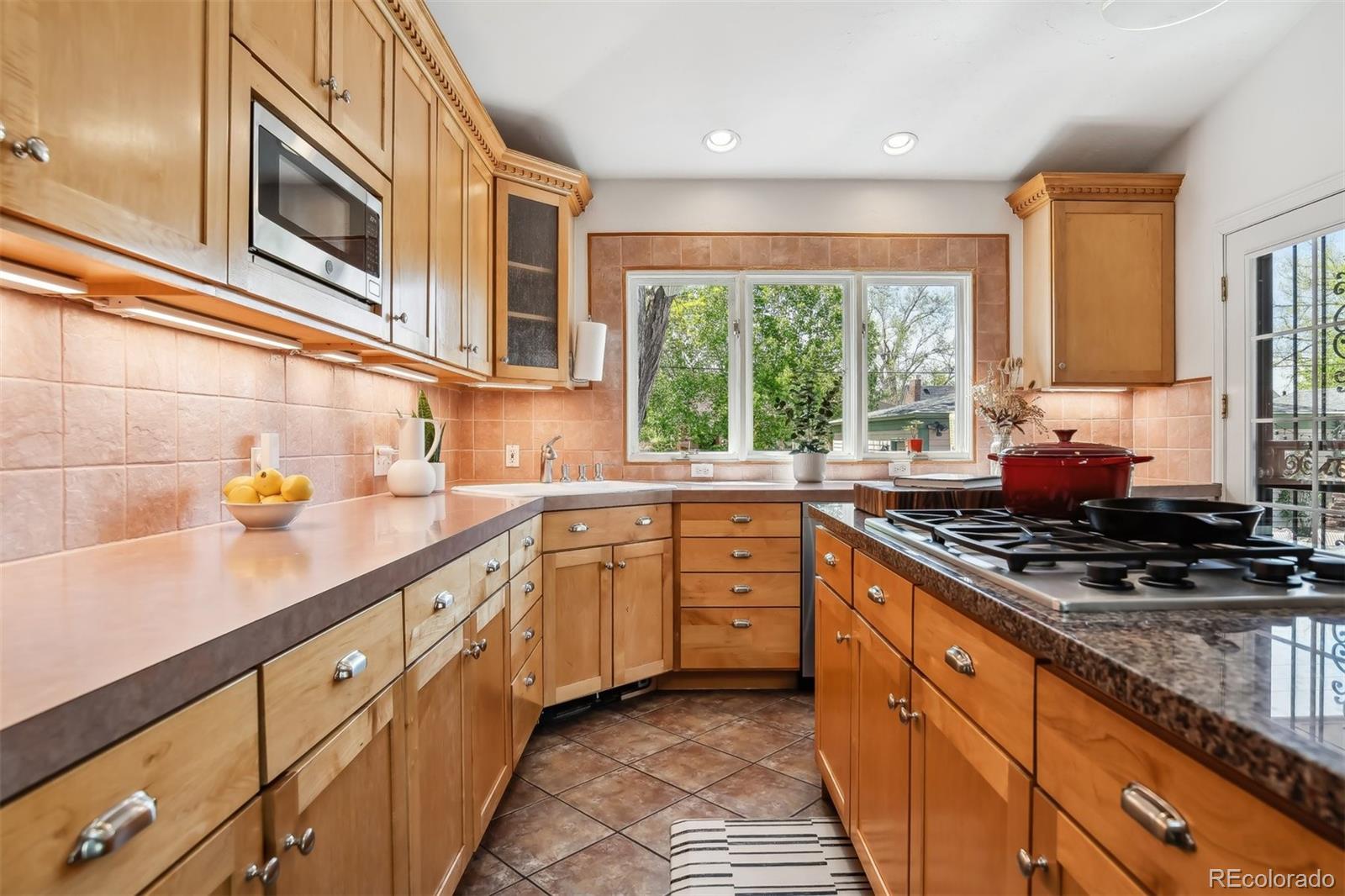 1377 Cherry Street Denver, CO 80220 - Photo 16 of 50 a kitchen with stainless steel appliances granite countertop a sink and a stove