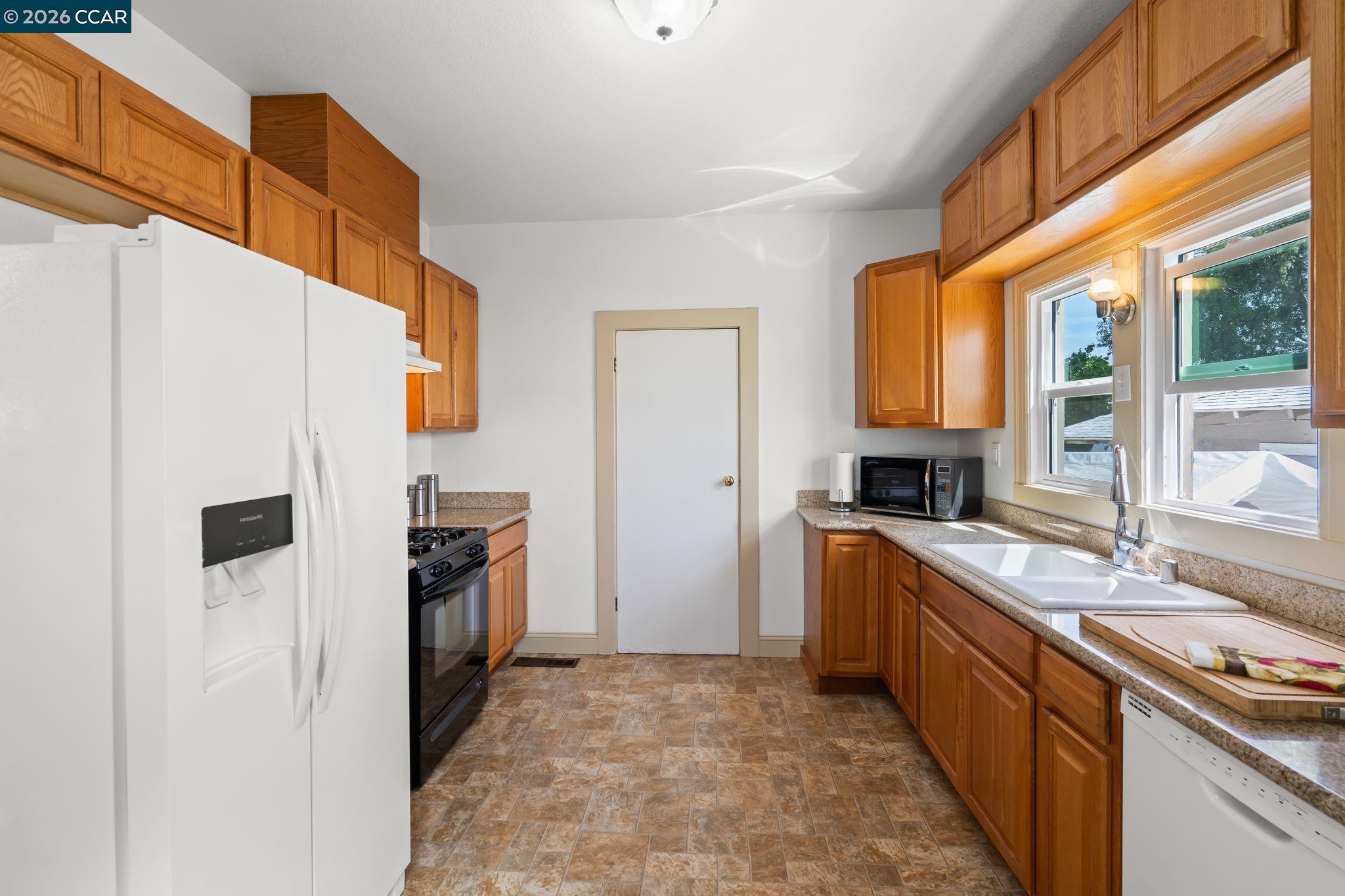 272 West 10th Street Pittsburg, CA 94565 - Photo 11 of 29 a kitchen with granite countertop a sink stove and refrigerator