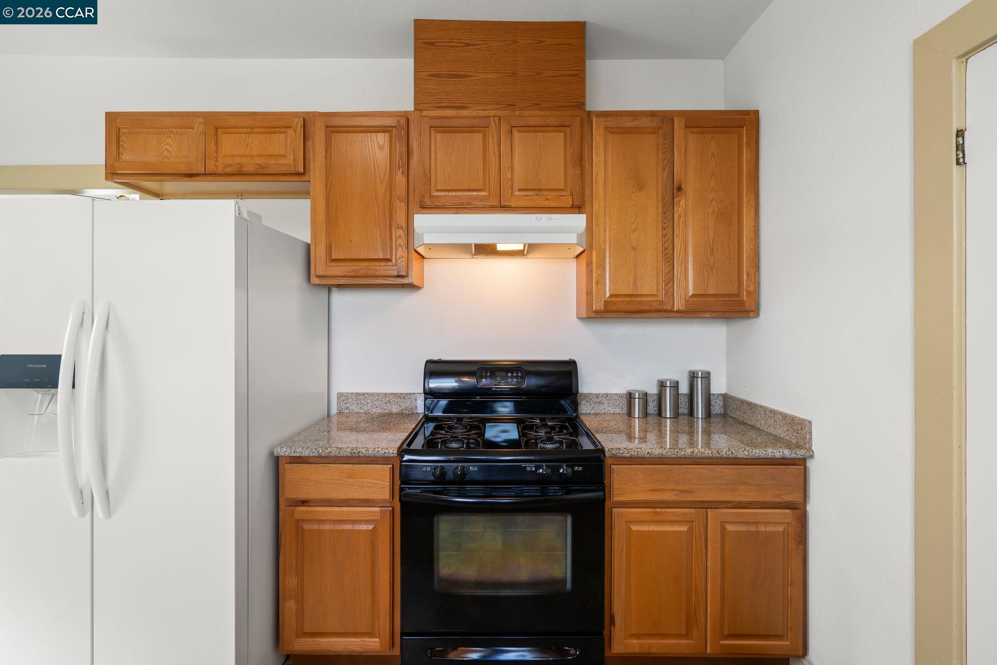 272 West 10th Street Pittsburg, CA 94565 - Photo 13 of 29 a kitchen with stainless steel appliances granite countertop white cabinets and a stove