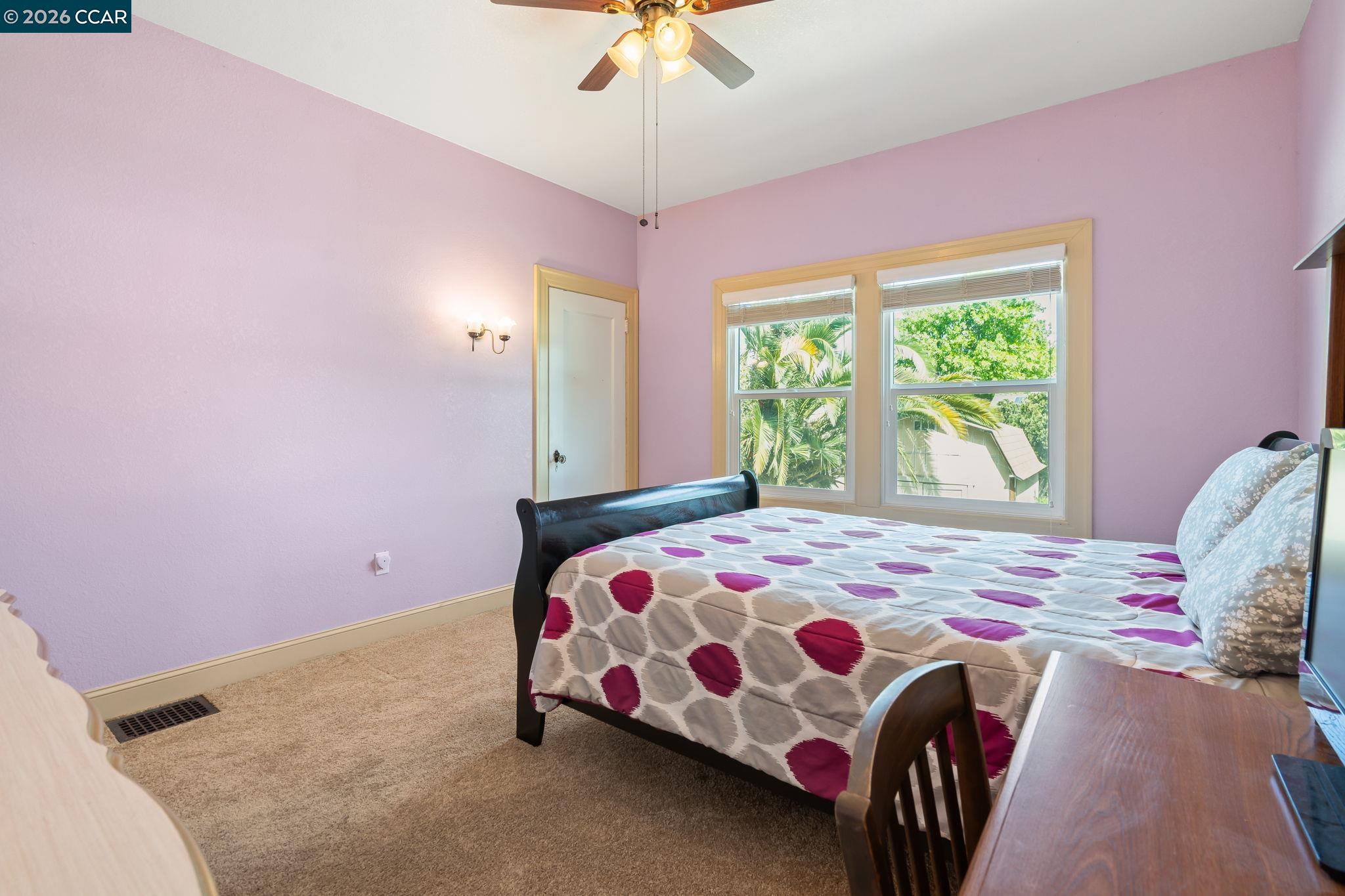 272 West 10th Street Pittsburg, CA 94565 - Photo 16 of 29 a bedroom with a bed and a chandelier