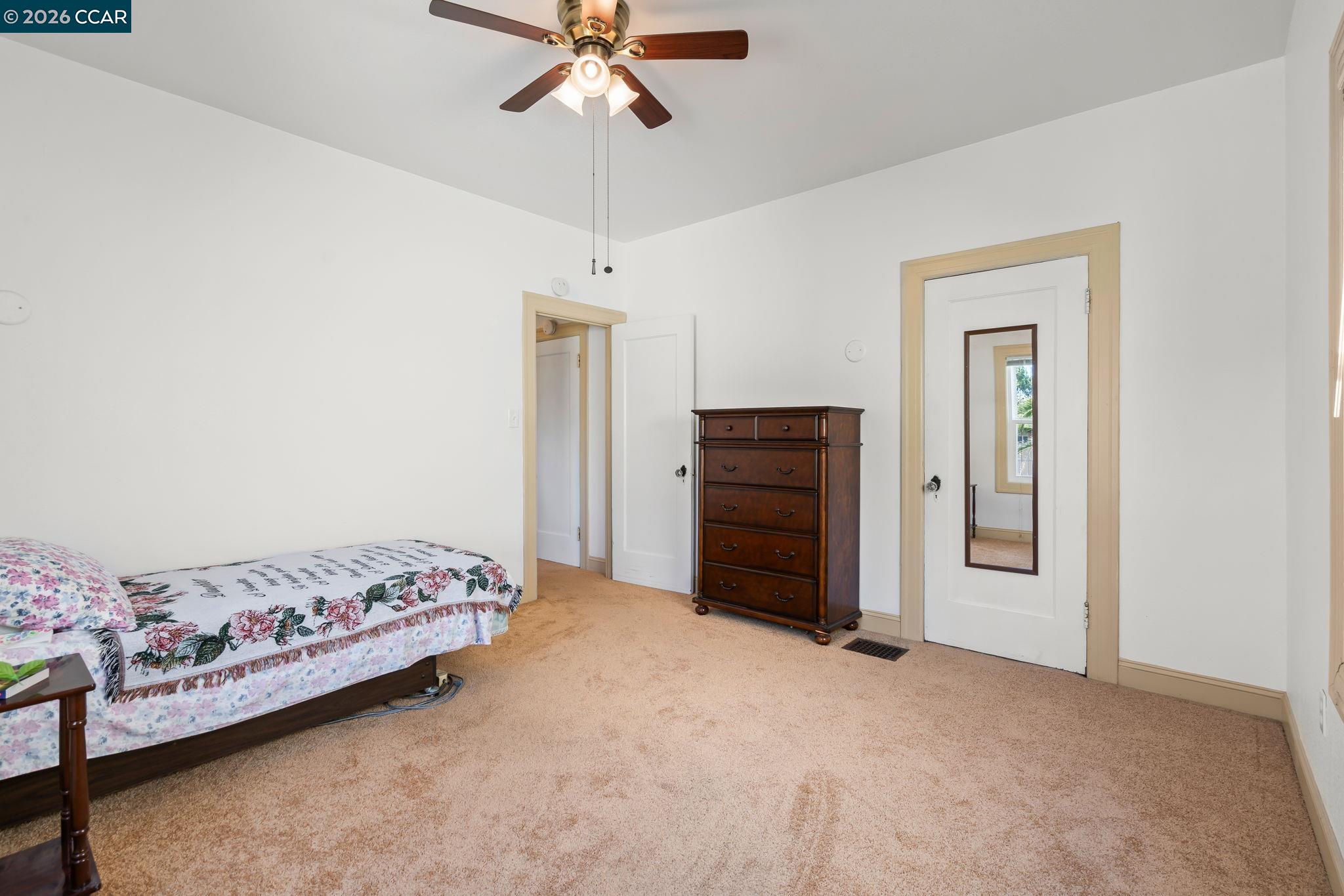 272 West 10th Street Pittsburg, CA 94565 - Photo 18 of 29 a bedroom with a bed and a chandelier fan