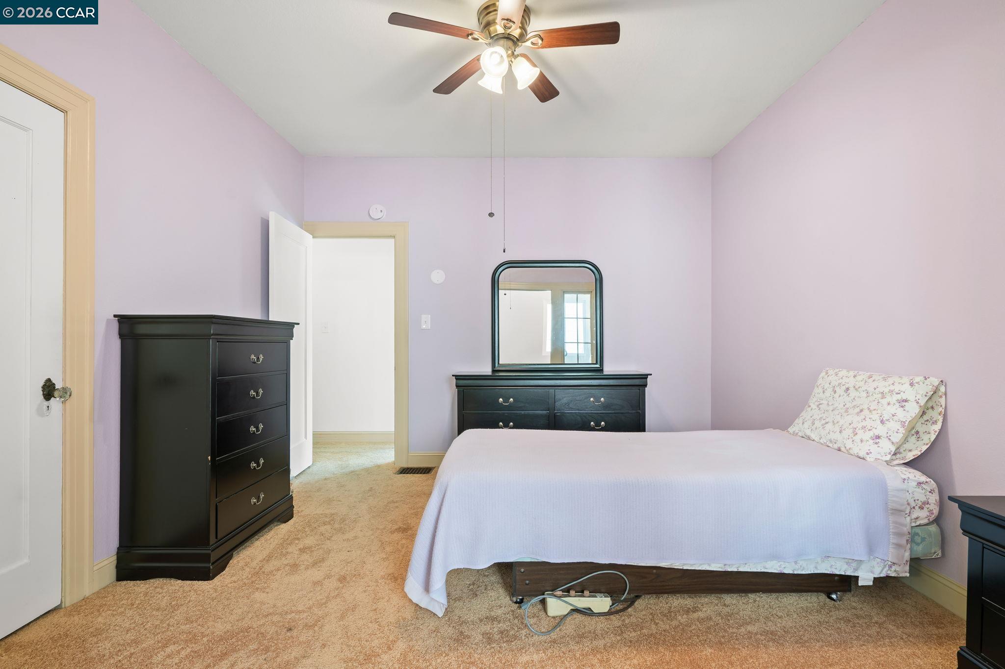 272 West 10th Street Pittsburg, CA 94565 - Photo 22 of 29 a bedroom with a bed and a chandelier