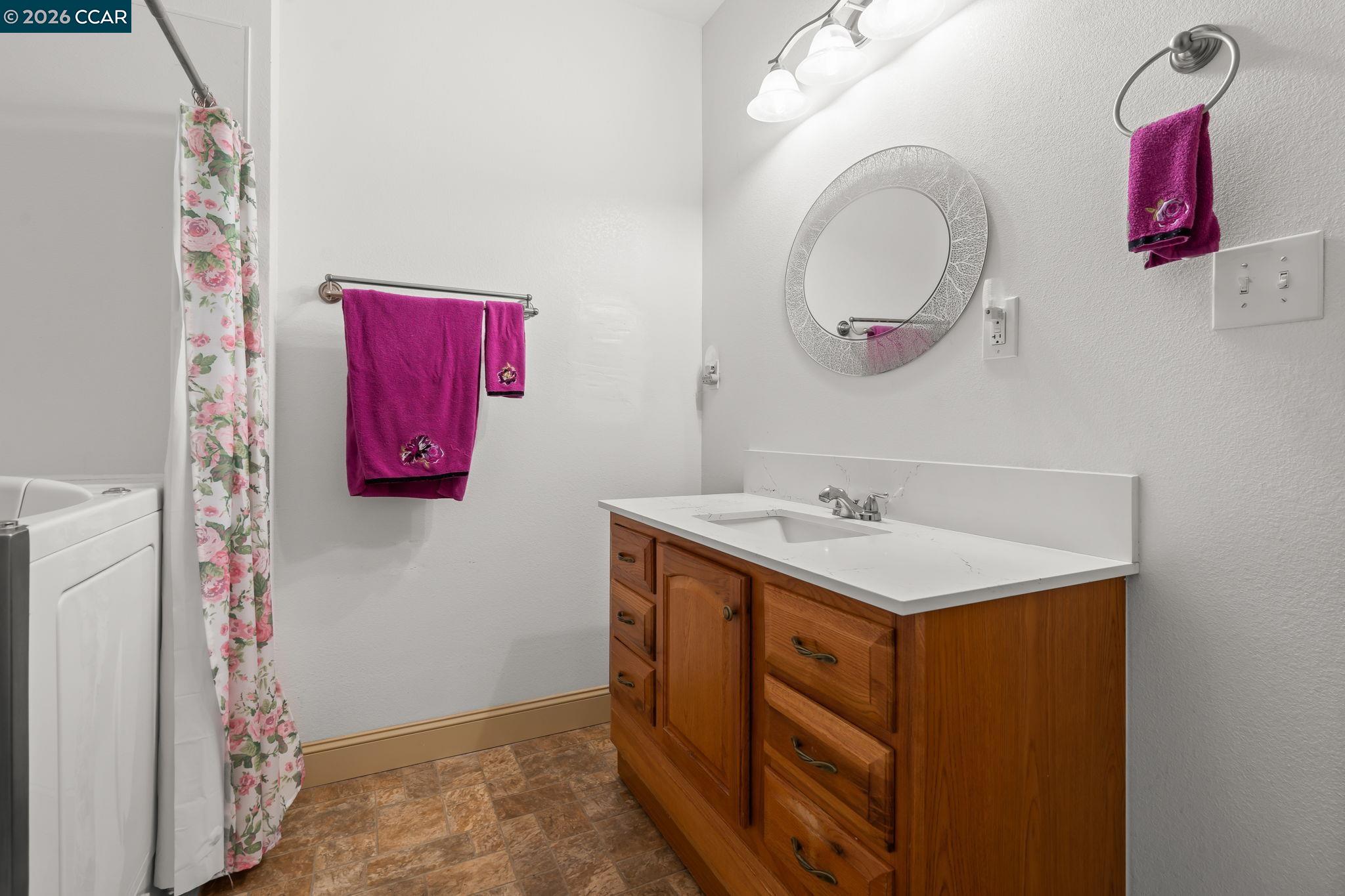 272 West 10th Street Pittsburg, CA 94565 - Photo 24 of 29 a bathroom with a sink vanity and a mirror
