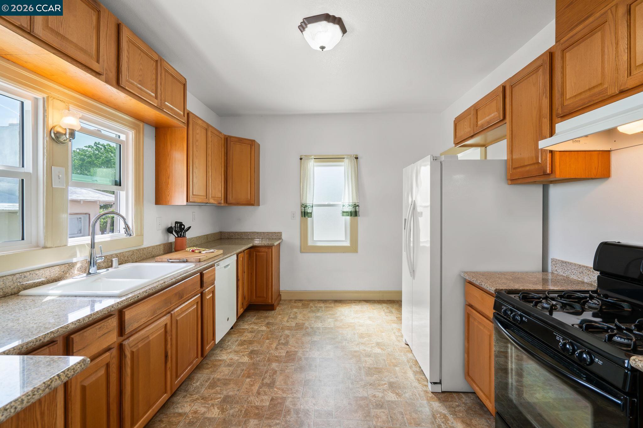 272 West 10th Street Pittsburg, CA 94565 - Photo 10 of 29 a kitchen with a sink stove and refrigerator