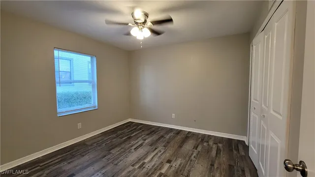 an empty room with a window and wooden floor