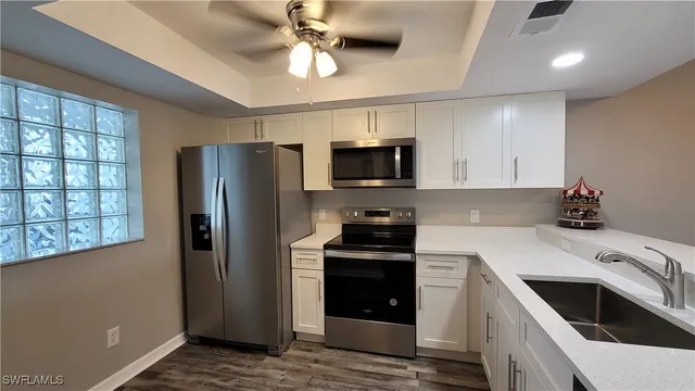 a kitchen with stainless steel appliances a stove a sink dishwasher a refrigerator and a microwave