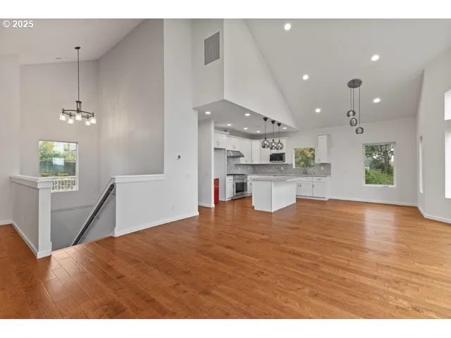 a view of a kitchen with kitchen island wooden floors wooden floor and appliances