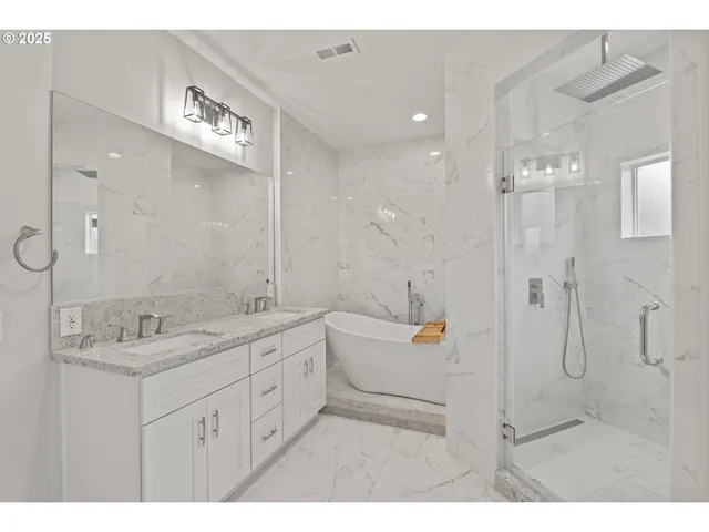 a bathroom with a double vanity sink a toilet a mirror and shower