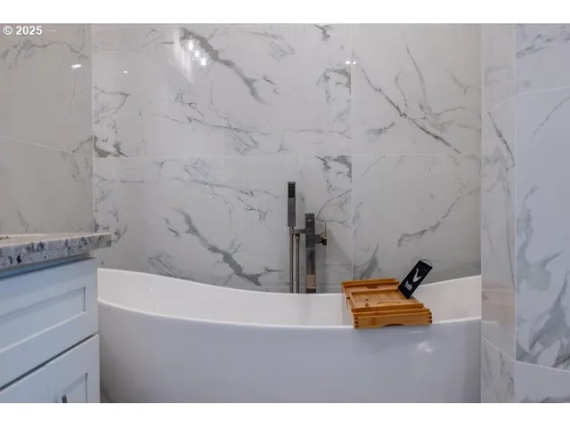 a bath tub sitting next to a bathroom sink