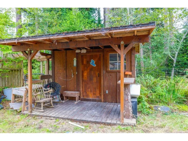 an aerial view of residential house with outdoor space and trees all around