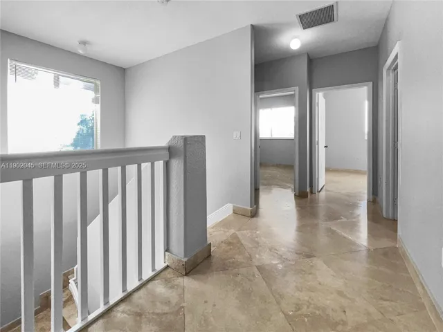 a view of an empty room with window and a livingroom