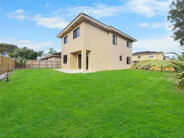 a view of a house with backyard and a tree