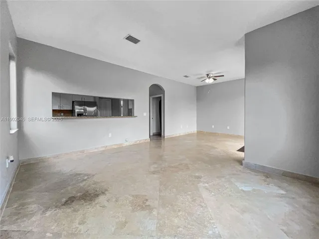 an empty room with windows and fireplace