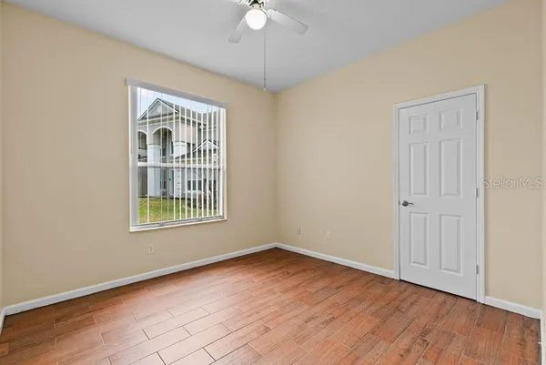 an empty room with wooden floor and windows