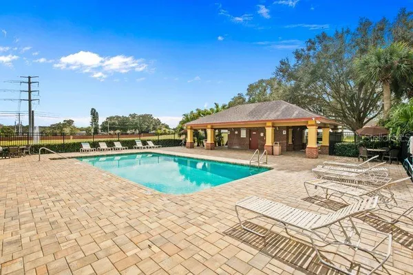 a view of an empty room with wooden floor and a ceiling fan