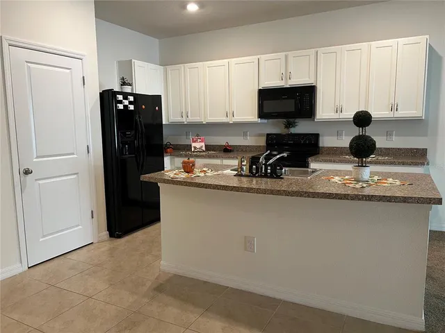 a kitchen with a sink a counter top space cabinets and stainless steel appliances